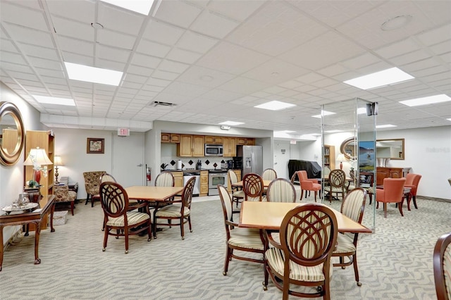dining area with light colored carpet, baseboards, and a drop ceiling