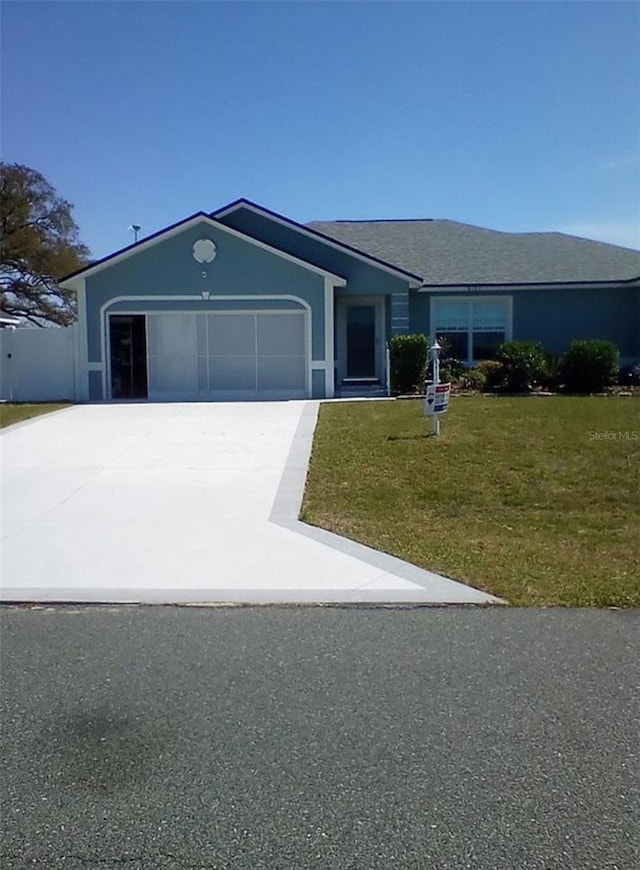 ranch-style house featuring a front lawn, driveway, and a garage