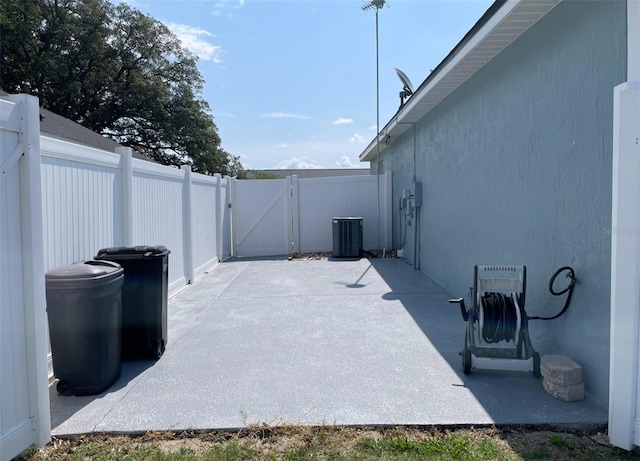 view of patio with cooling unit, a gate, and fence