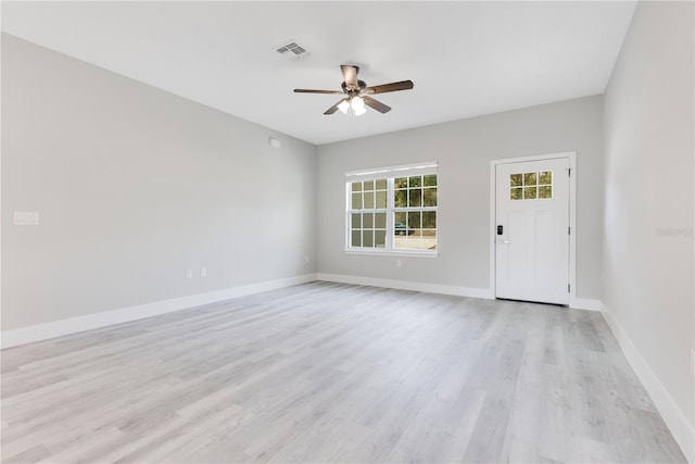 unfurnished room with a ceiling fan, light wood-style floors, and baseboards