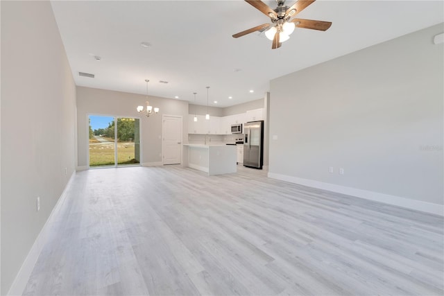 unfurnished living room featuring a chandelier, a ceiling fan, recessed lighting, baseboards, and light wood finished floors