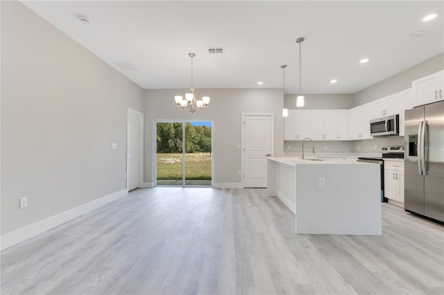 kitchen with stainless steel appliances, a sink, light countertops, a chandelier, and baseboards