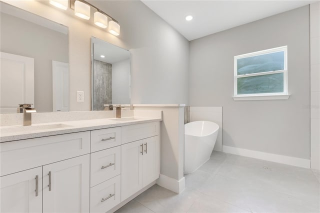bathroom featuring baseboards, double vanity, a freestanding tub, tiled shower, and tile patterned floors