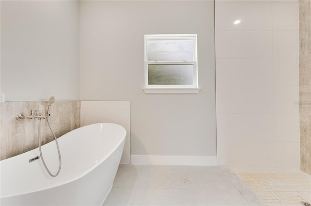full bath with a freestanding tub and tile patterned flooring