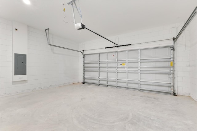 garage featuring electric panel, a garage door opener, and concrete block wall