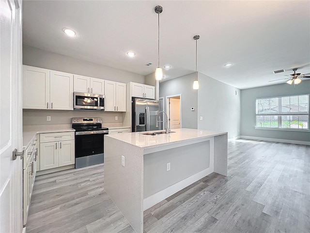 2531 SW 167th Loop, Ocala, FL 34473 - kitchen featuring stainless steel appliances, a sink, light wood finished floors, light countertops, and a center island with sink