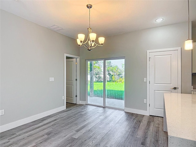 2531 SW 167th Loop, Ocala, FL 34473 - unfurnished dining area with a chandelier, dark wood finished floors, and baseboards