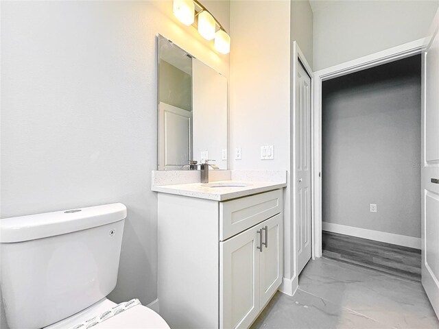 2531 SW 167th Loop, Ocala, FL 34473 - bathroom with marble finish flooring, toilet, vanity, and baseboards