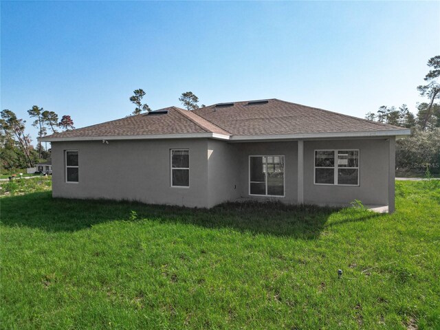 2531 SW 167th Loop, Ocala, FL 34473 - back of property with stucco siding, a lawn, and roof with shingles