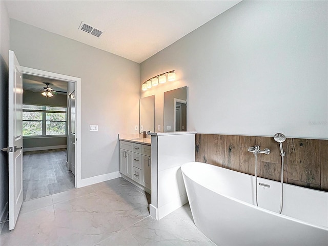2531 SW 167th Loop, Ocala, FL 34473 - full bath with marble finish floors, vanity, a soaking tub, baseboards, and ceiling fan