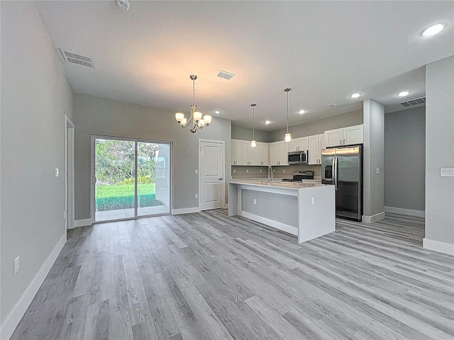 2531 SW 167th Loop, Ocala, FL 34473 - kitchen with appliances with stainless steel finishes, a sink, baseboards, light countertops, and a chandelier