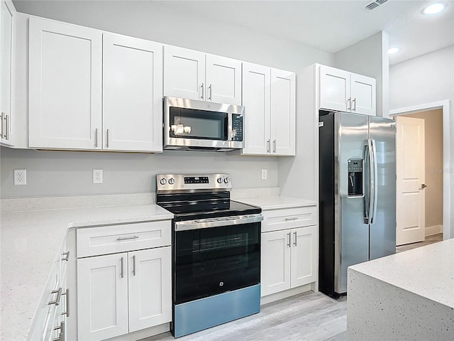 2531 SW 167th Loop, Ocala, FL 34473 - kitchen featuring stainless steel appliances, recessed lighting, white cabinets, light wood-style floors, and light stone counters