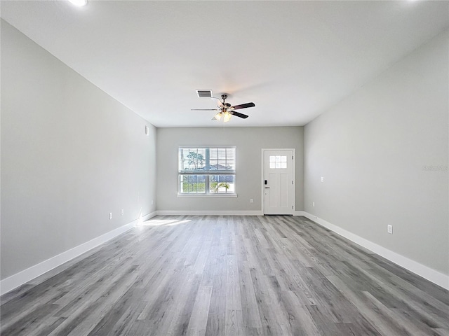 2531 SW 167th Loop, Ocala, FL 34473 - unfurnished living room featuring wood finished floors, baseboards, and a ceiling fan