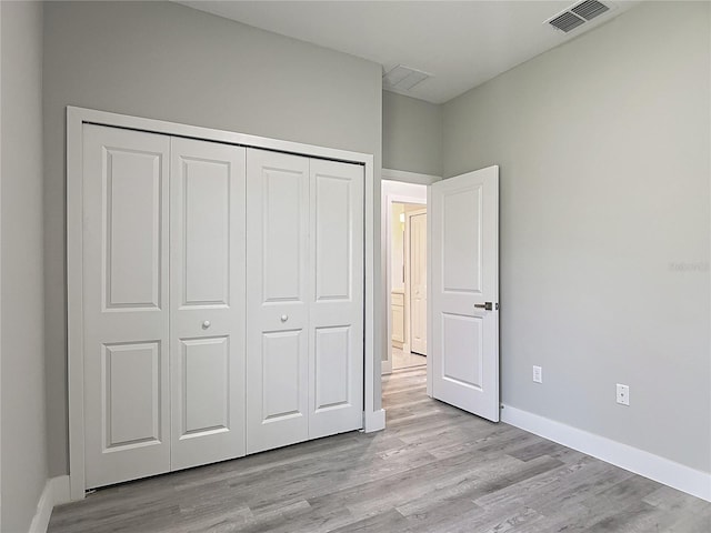 2531 SW 167th Loop, Ocala, FL 34473 - unfurnished bedroom featuring light wood-type flooring, a closet, and baseboards