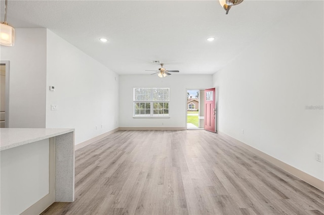 unfurnished living room featuring a ceiling fan, light wood finished floors, recessed lighting, and baseboards