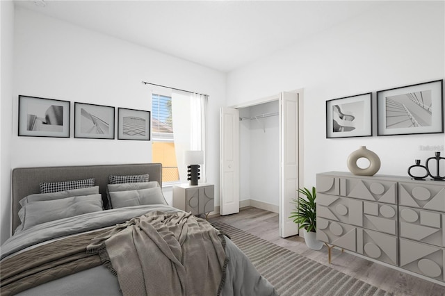 bedroom featuring wood finished floors, a closet, and baseboards