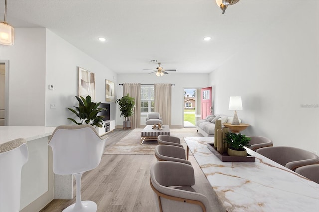 living room featuring light wood finished floors, ceiling fan, and recessed lighting