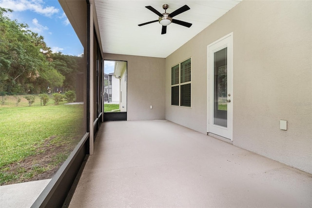 unfurnished sunroom featuring ceiling fan