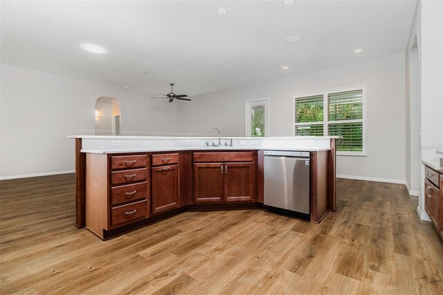 kitchen featuring dishwasher, light countertops, a ceiling fan, a sink, and light wood-style floors