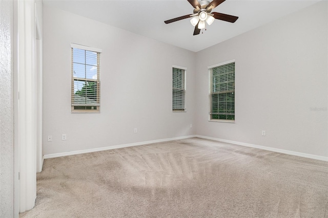 unfurnished room with light carpet, baseboards, and ceiling fan