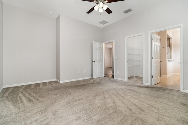 unfurnished bedroom featuring carpet, a walk in closet, baseboards, and a closet