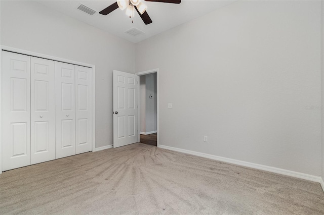 unfurnished bedroom featuring carpet floors, a closet, baseboards, and ceiling fan