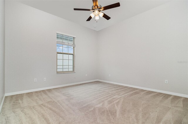 carpeted empty room with baseboards and a ceiling fan