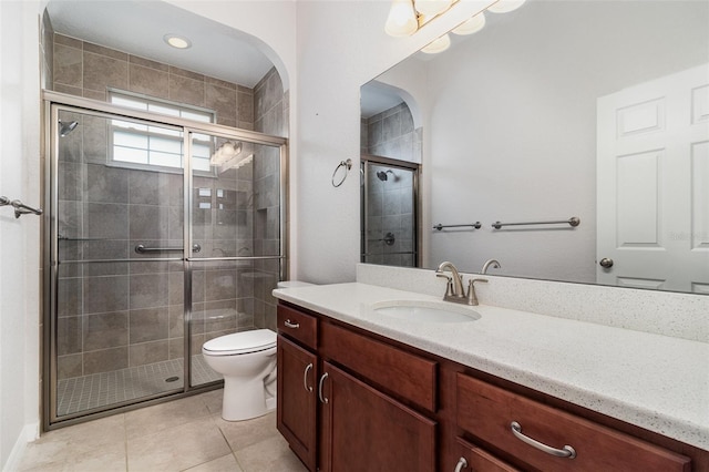 full bath featuring a stall shower, vanity, toilet, and tile patterned floors