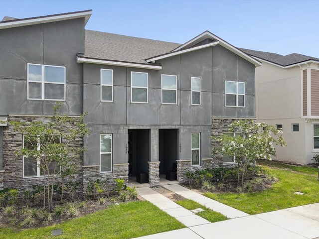 1632 Tropical Palms Cir, Kissimmee, FL 34747 - view of front facade featuring stone siding, stucco siding, and a shingled roof