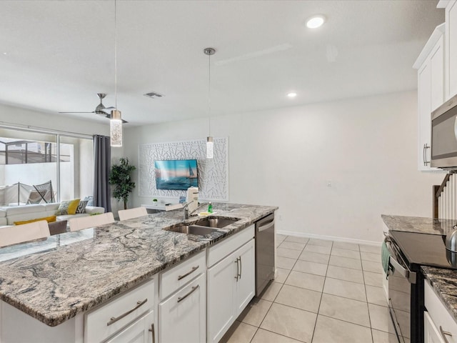 1632 Tropical Palms Cir, Kissimmee, FL 34747 - kitchen featuring stainless steel appliances, a sink, open floor plan, decorative light fixtures, and white cabinetry