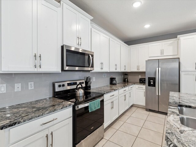 1632 Tropical Palms Cir, Kissimmee, FL 34747 - kitchen featuring appliances with stainless steel finishes, light tile patterned floors, white cabinets, decorative backsplash, and recessed lighting