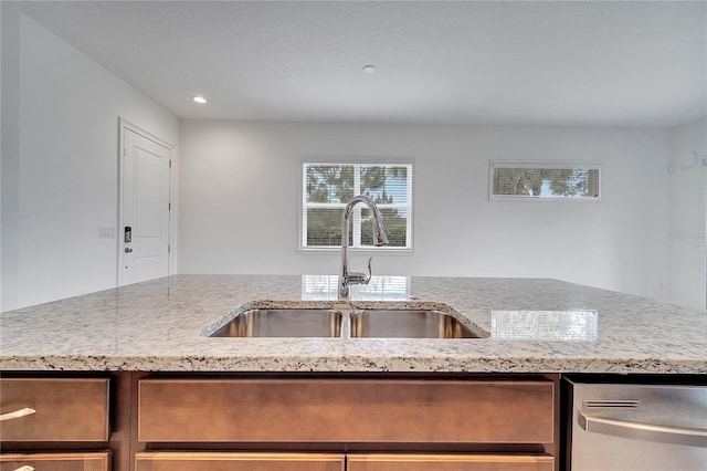 kitchen featuring a sink, stainless steel dishwasher, light stone countertops, and recessed lighting