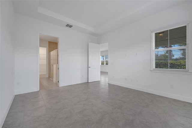 empty room featuring baseboards and a tray ceiling