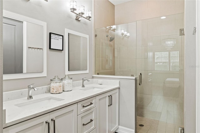 bathroom featuring a shower stall and double vanity