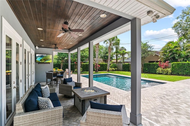 view of pool featuring a fenced backyard, a patio, a ceiling fan, an outdoor living space with a fire pit, and outdoor dining area