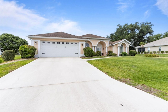single story home with concrete driveway, a front lawn, an attached garage, and stucco siding