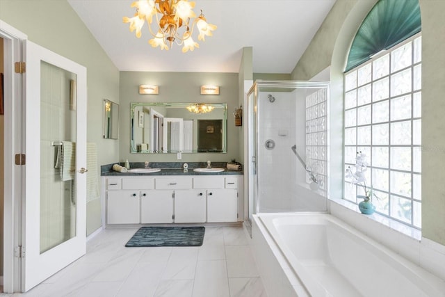 bathroom featuring a shower stall, vanity, a chandelier, vaulted ceiling, and a bath