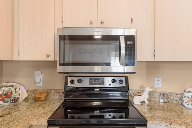 kitchen featuring stainless steel appliances, light stone countertops, and light brown cabinetry