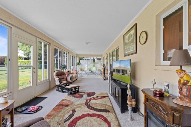 sunroom / solarium with carpet flooring, healthy amount of natural light, and crown molding