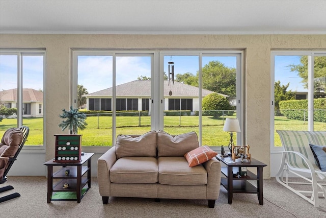 sunroom / solarium featuring ornamental molding, carpet flooring, plenty of natural light, and a textured wall