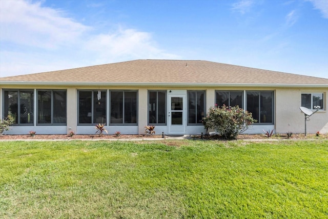 back of house featuring a sunroom, a yard, and roof with shingles