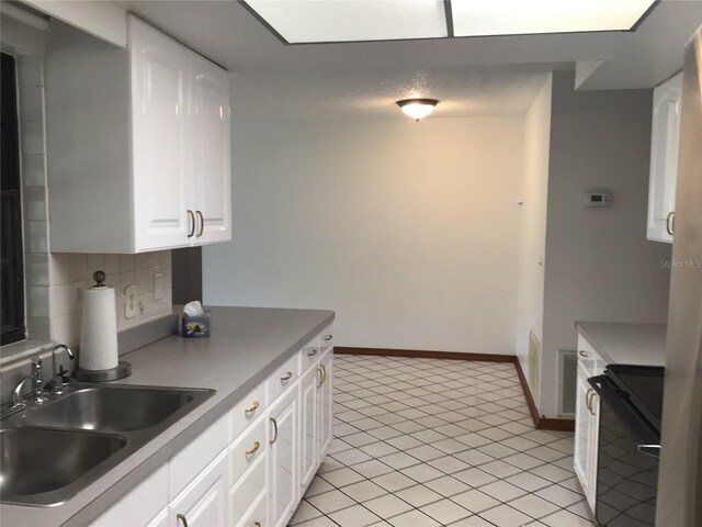 3152 Clewiston St, Deltona, FL 32738 - kitchen featuring range, a sink, light tile patterned floors, white cabinets, and decorative backsplash