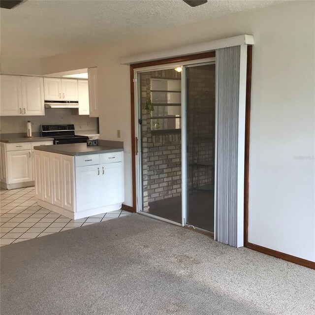 3152 Clewiston St, Deltona, FL 32738 - kitchen featuring electric range oven, under cabinet range hood, light carpet, dark countertops, and white cabinets