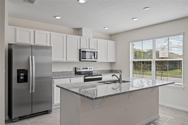 17081 Water Spring Blvd, Winter Garden, FL 34787 - kitchen featuring stainless steel appliances, a sink, white cabinets, a kitchen bar, and light stone countertops