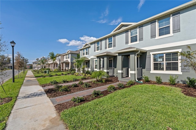 17081 Water Spring Blvd, Winter Garden, FL 34787 - townhome / multi-family property with a residential view, stucco siding, a front lawn, and central AC unit
