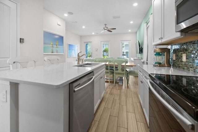 8045 Lost Shaker Ln, Kissimmee, FL 34747 - kitchen featuring appliances with stainless steel finishes, decorative backsplash, a ceiling fan, white cabinetry, and recessed lighting
