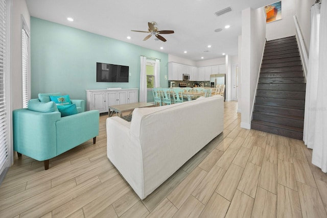 8045 Lost Shaker Ln, Kissimmee, FL 34747 - living room with ceiling fan, stairway, recessed lighting, and light wood-type flooring