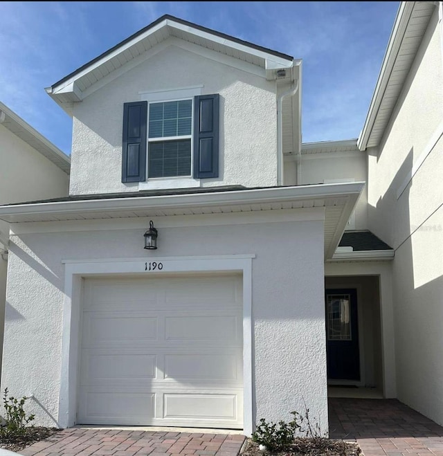 property entrance featuring an attached garage and stucco siding