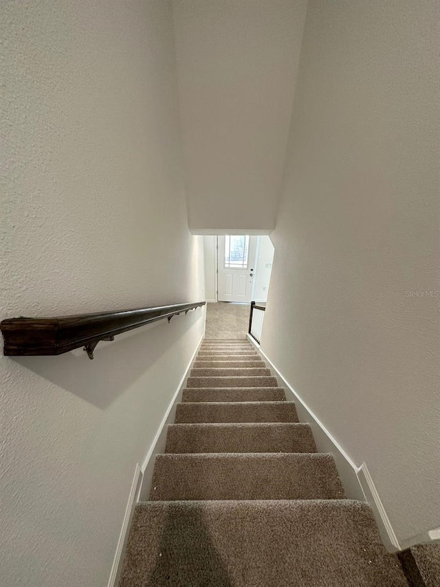 stairway with baseboards and carpet