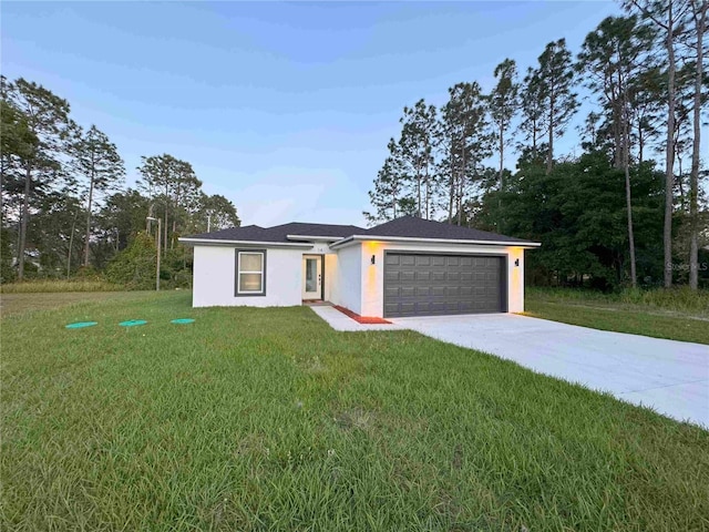 view of front of house with stucco siding, a garage, a front yard, and driveway